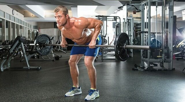 Guy working out in the gym lifting weights