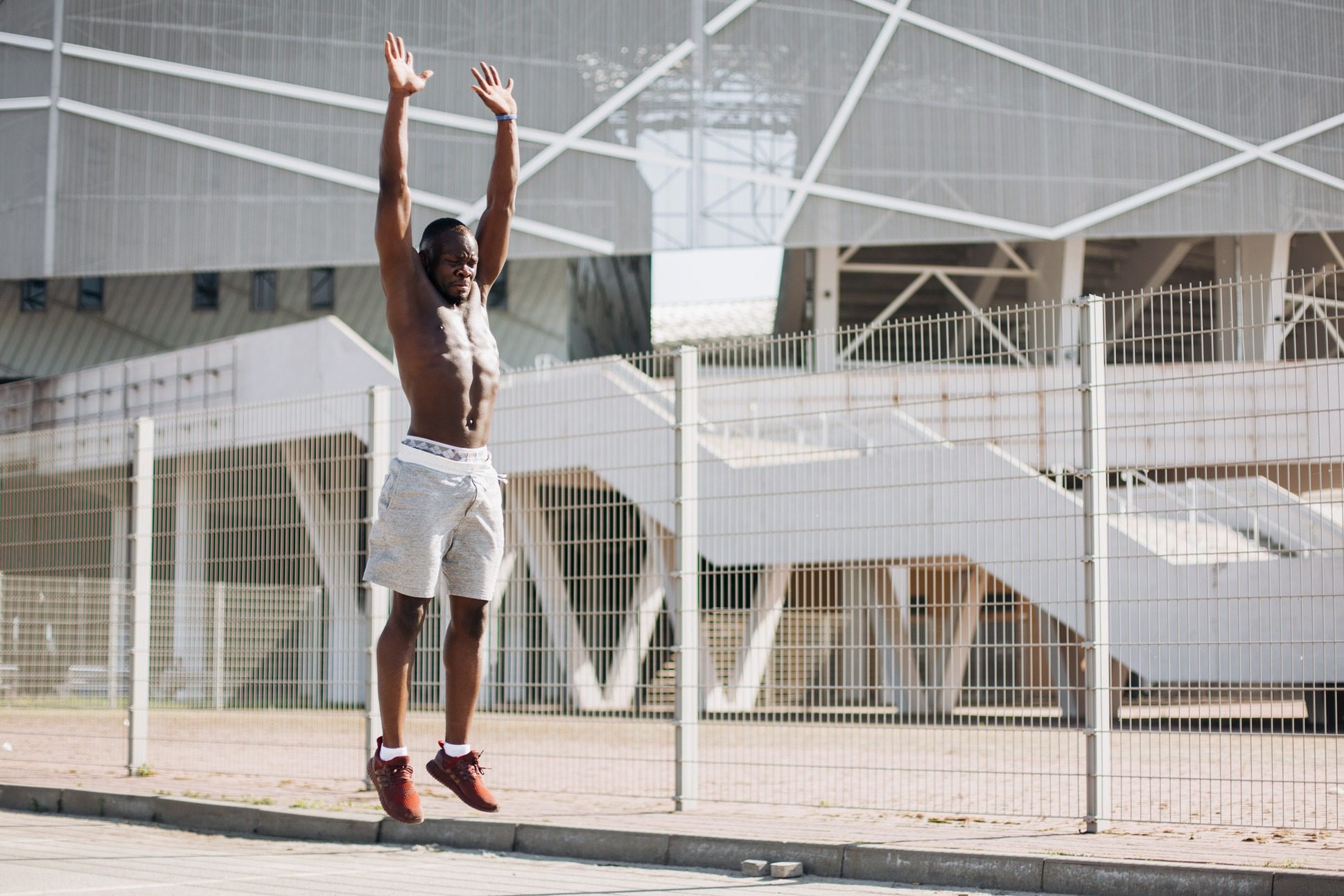 Attractive African American man does burpees working out on the street