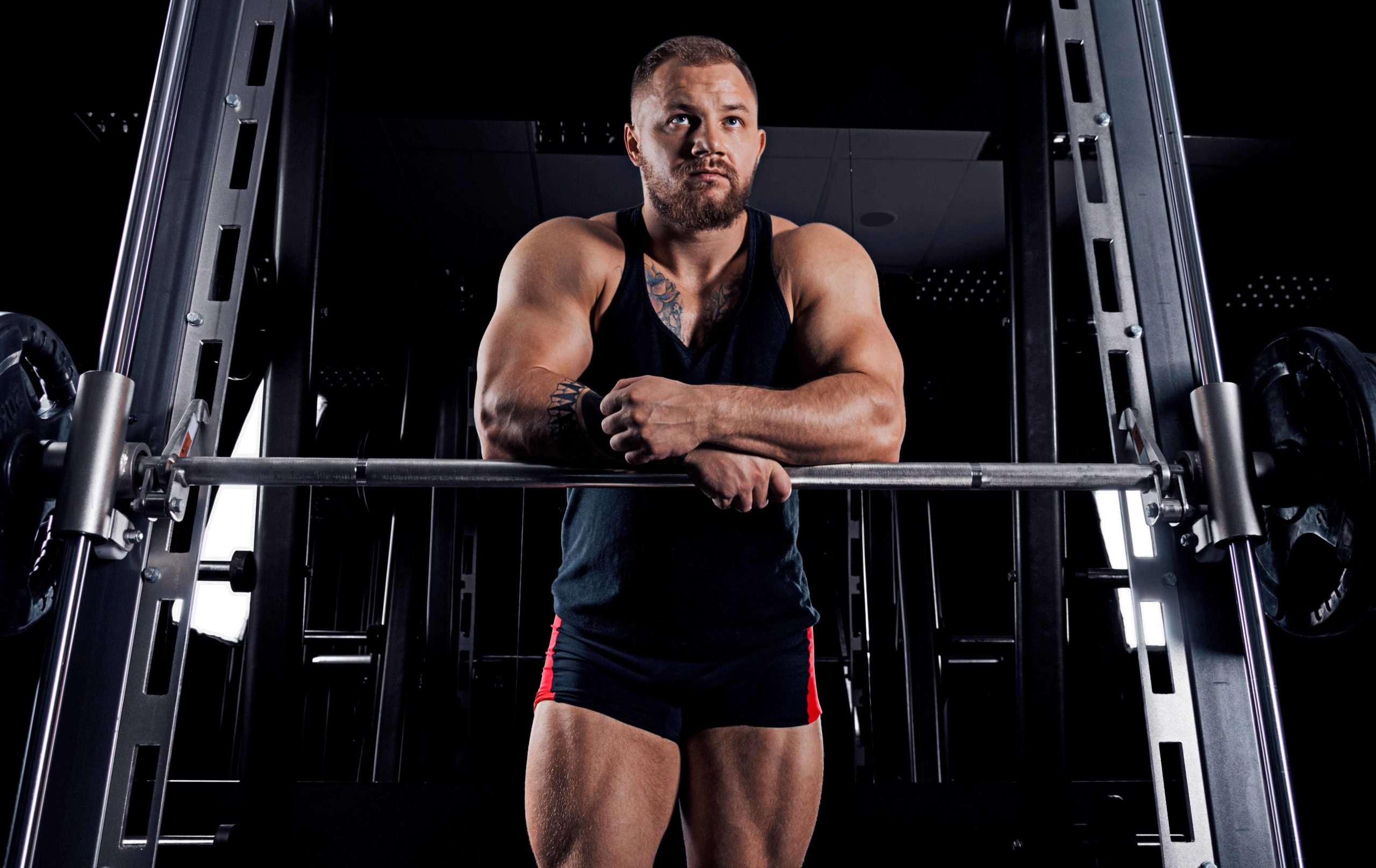 The weightlifter is near the bar, put his hands on it for a resp