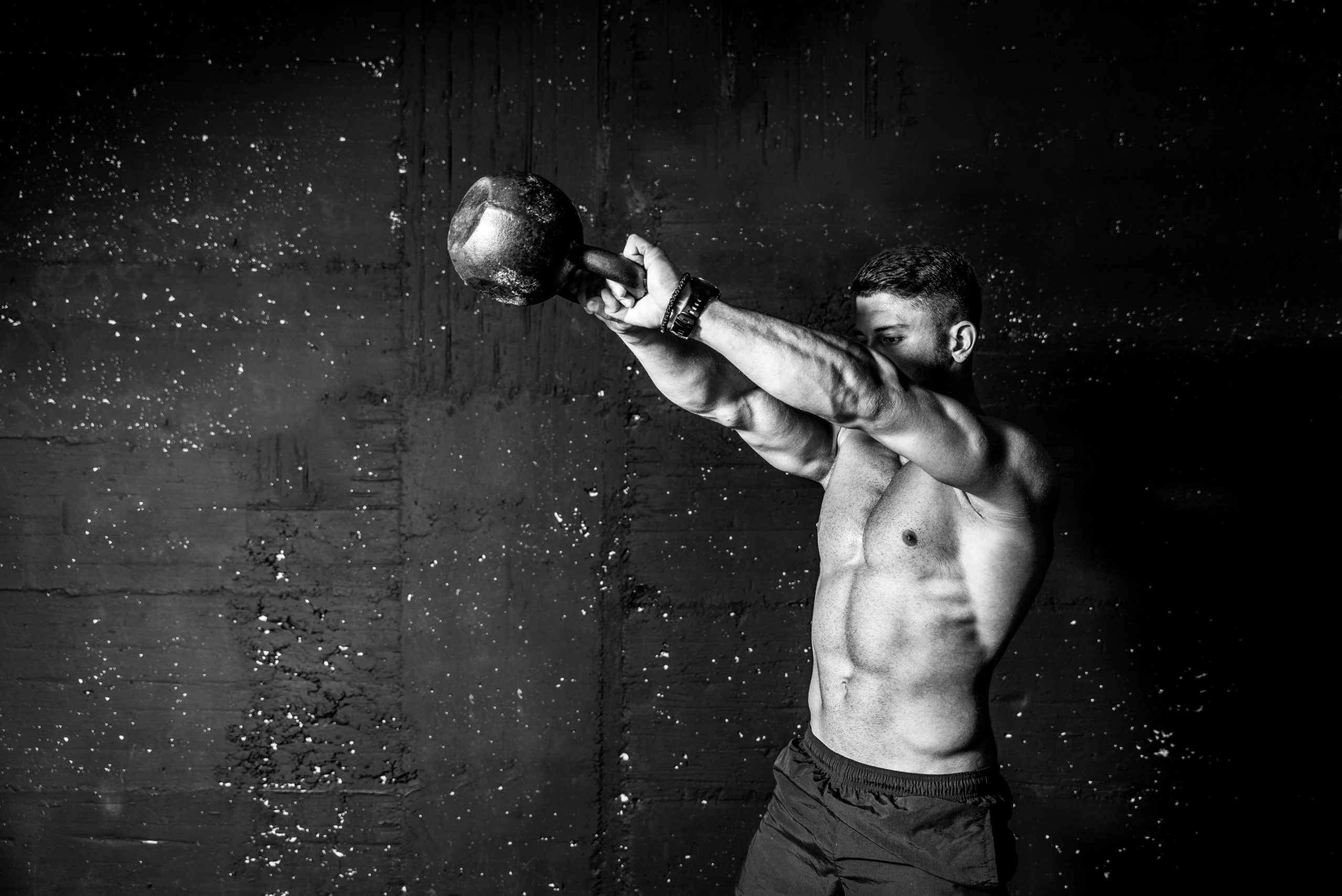 Strong, muscular man performing the kettlebell swing