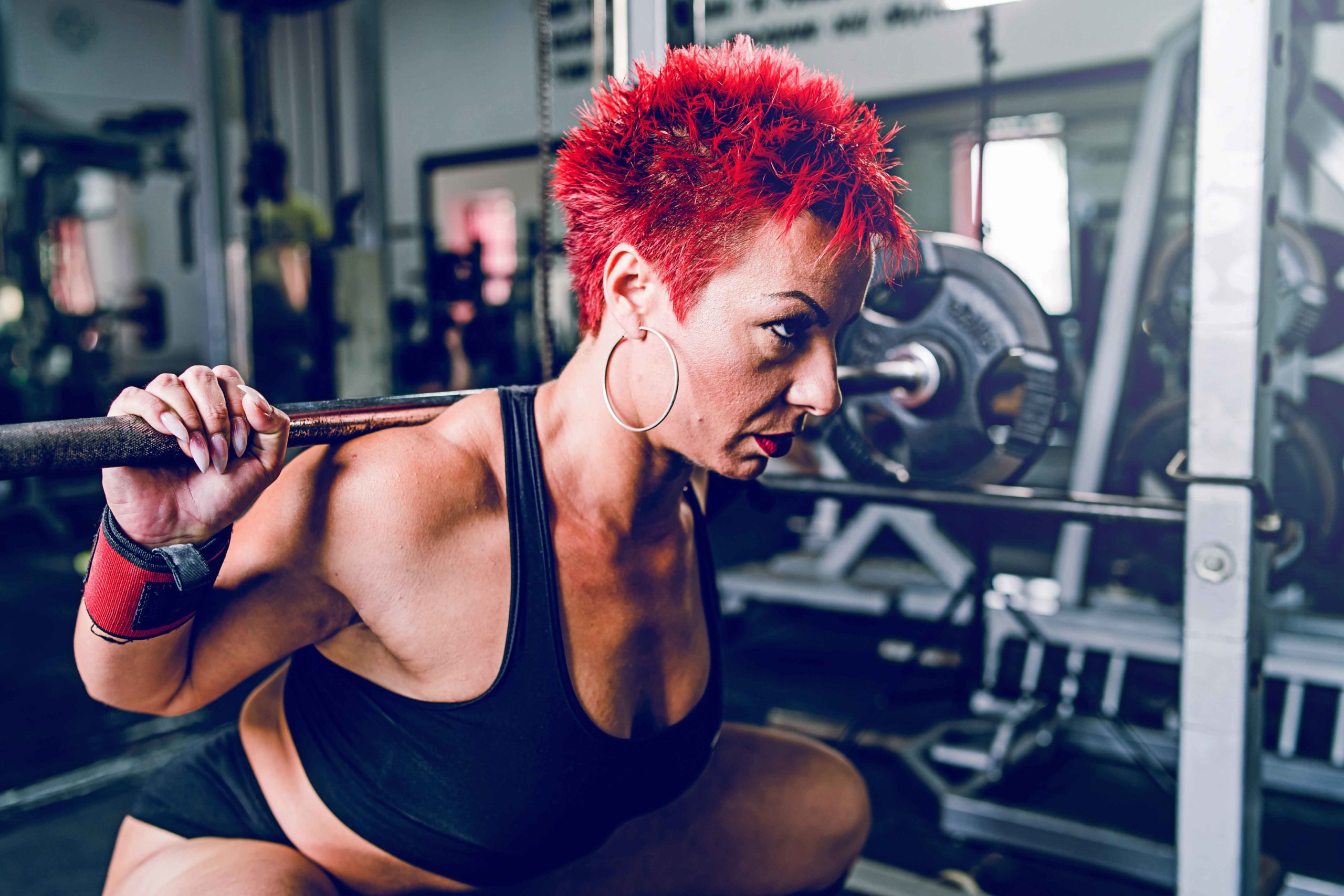 Close up on Olympic weightlifting woman training at the gym and performing a dead squat