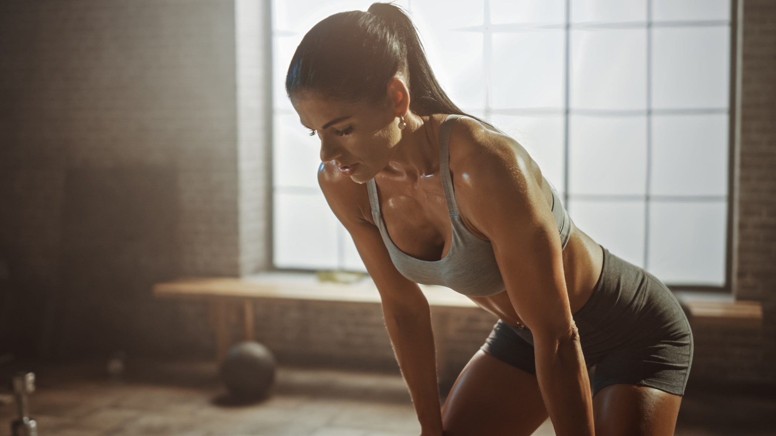 Portrait of a Strong Female Athlete Wiping Sweat from Face