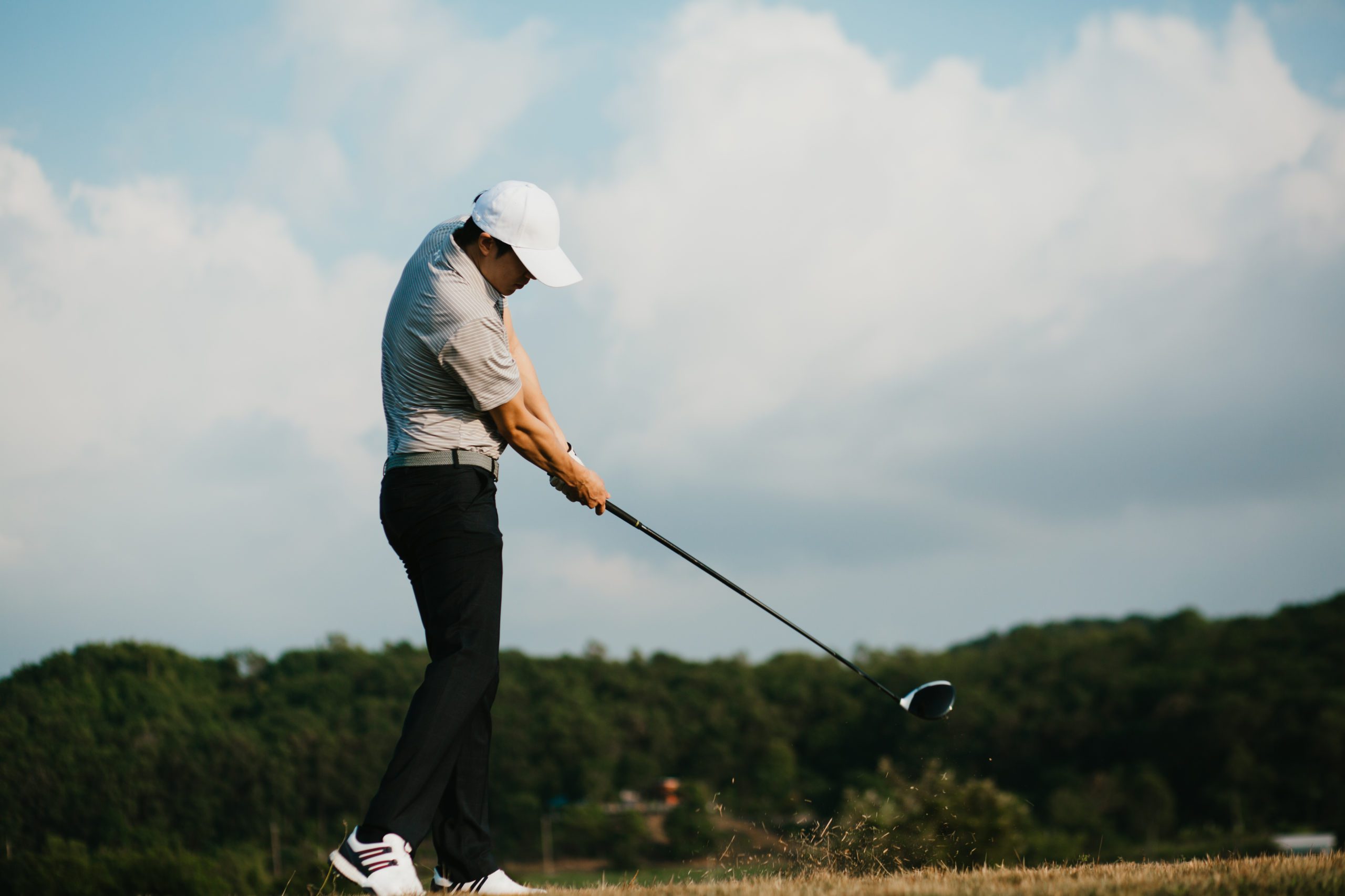 Golfer swinging golf club in a strong stance