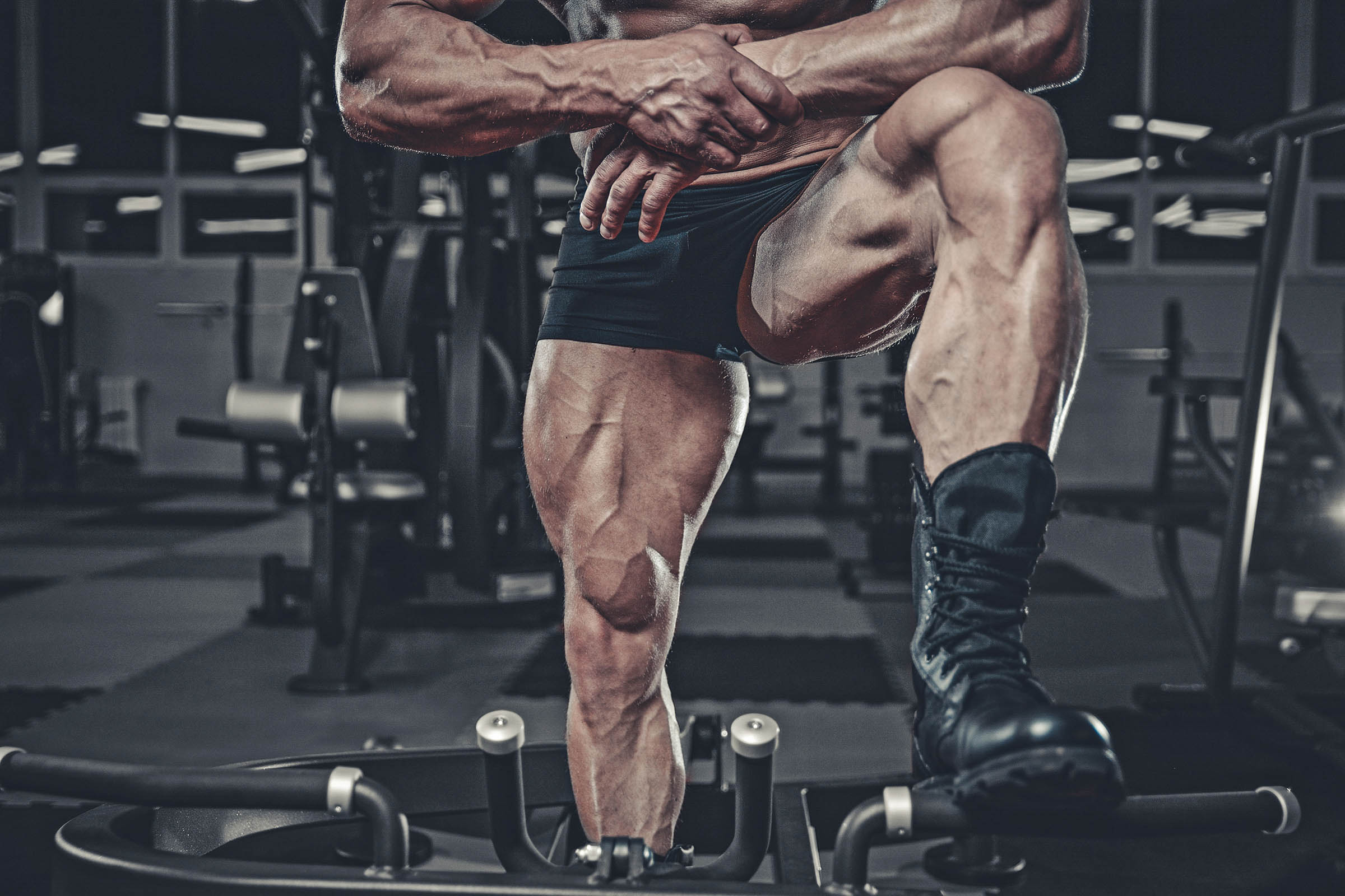 Fit couple doing squats with kettle bells during an