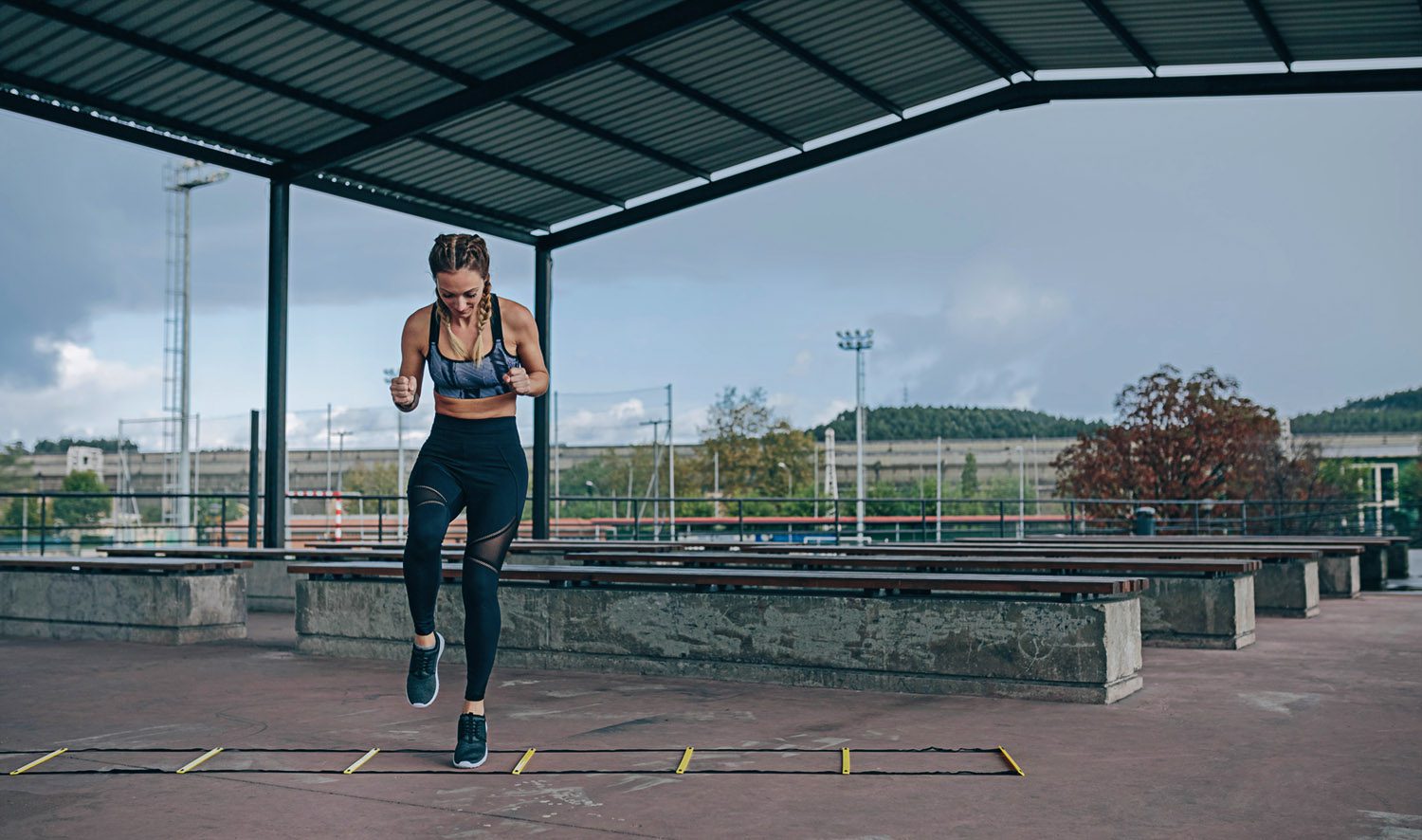 Woman training on an agility ladder outdoors