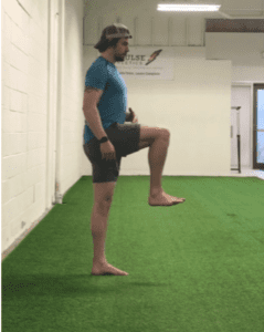 Man doing bucket hold speed training exercise on turf grass