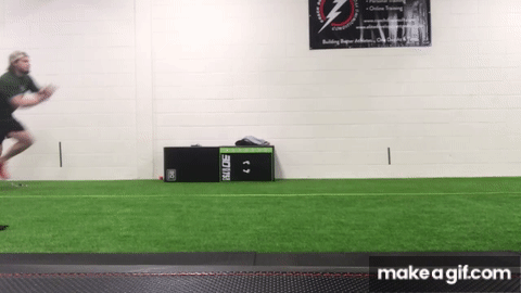 Man doing bounding spring exercise speed drills on indoor turf
