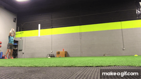 Man performing double leg hop standing broad jump sprinting exercise on indoor field