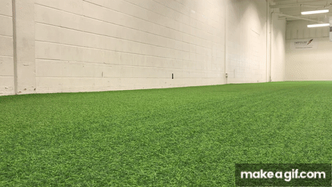 Man doing 3 double leg hops in a row on indoor turf field 