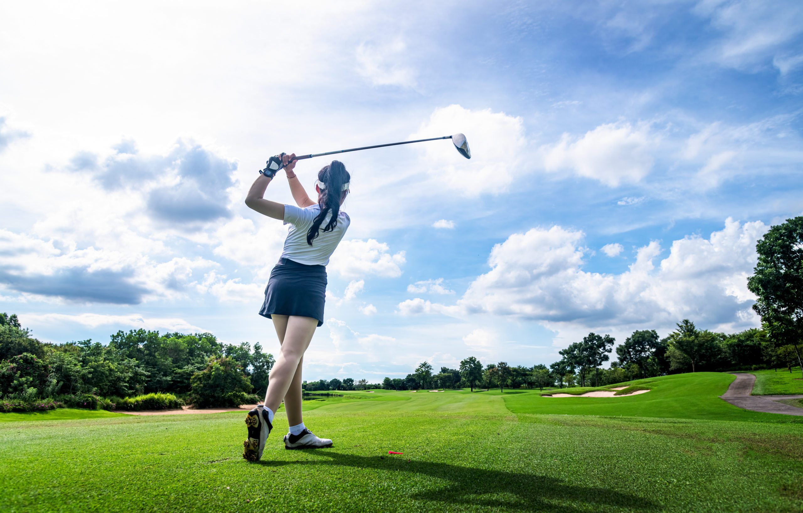 Professional woman golfer teeing in golf tournament