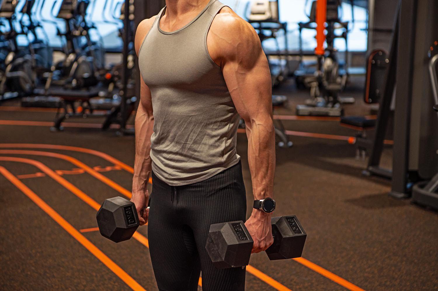 cropped view of sportsman do weightlifting with dumbbell in fitness gym. weightlifting sportsman