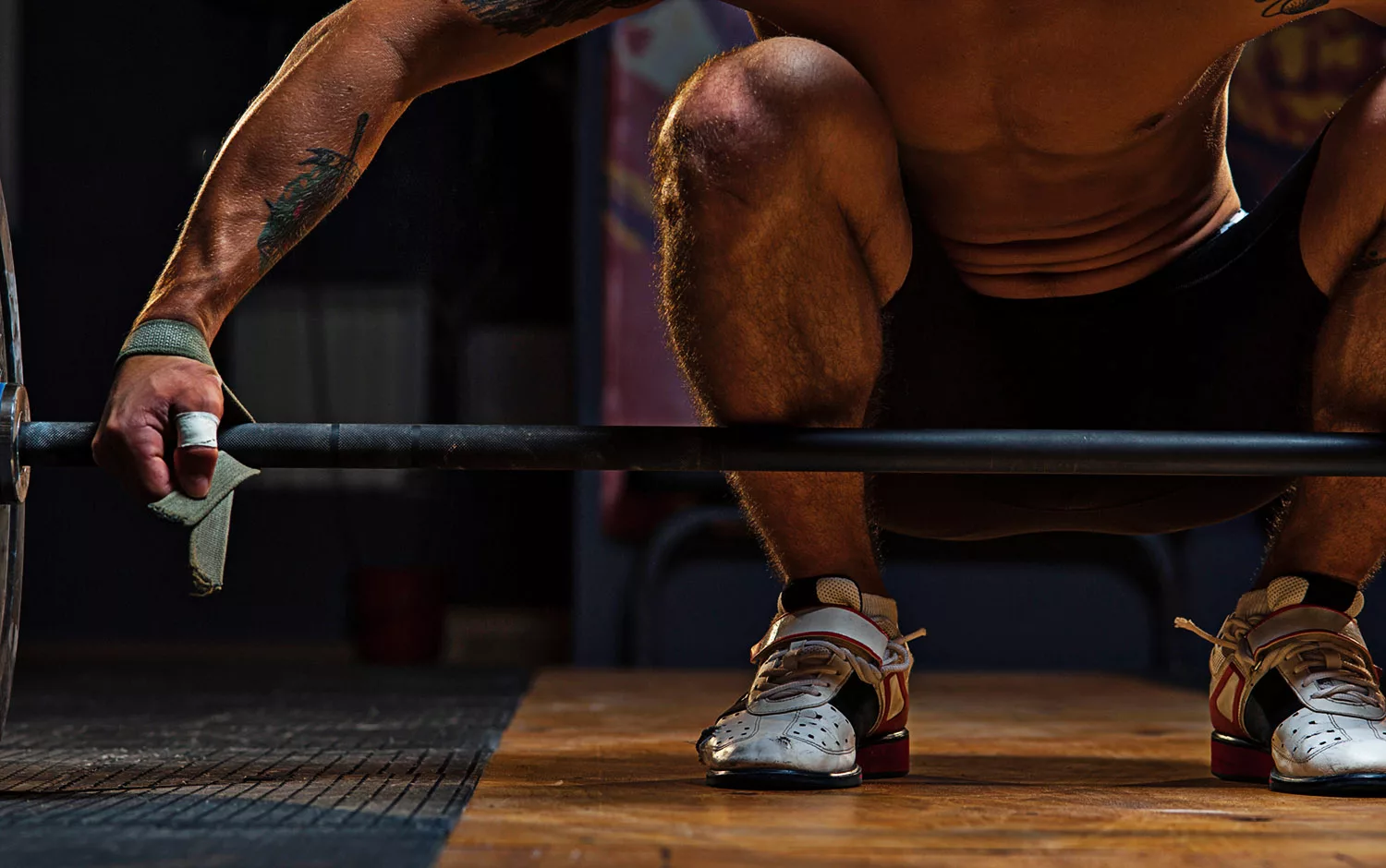 Male athlete preparing for exercise with barbell progressive overload training for olymoic weightlifting athletes