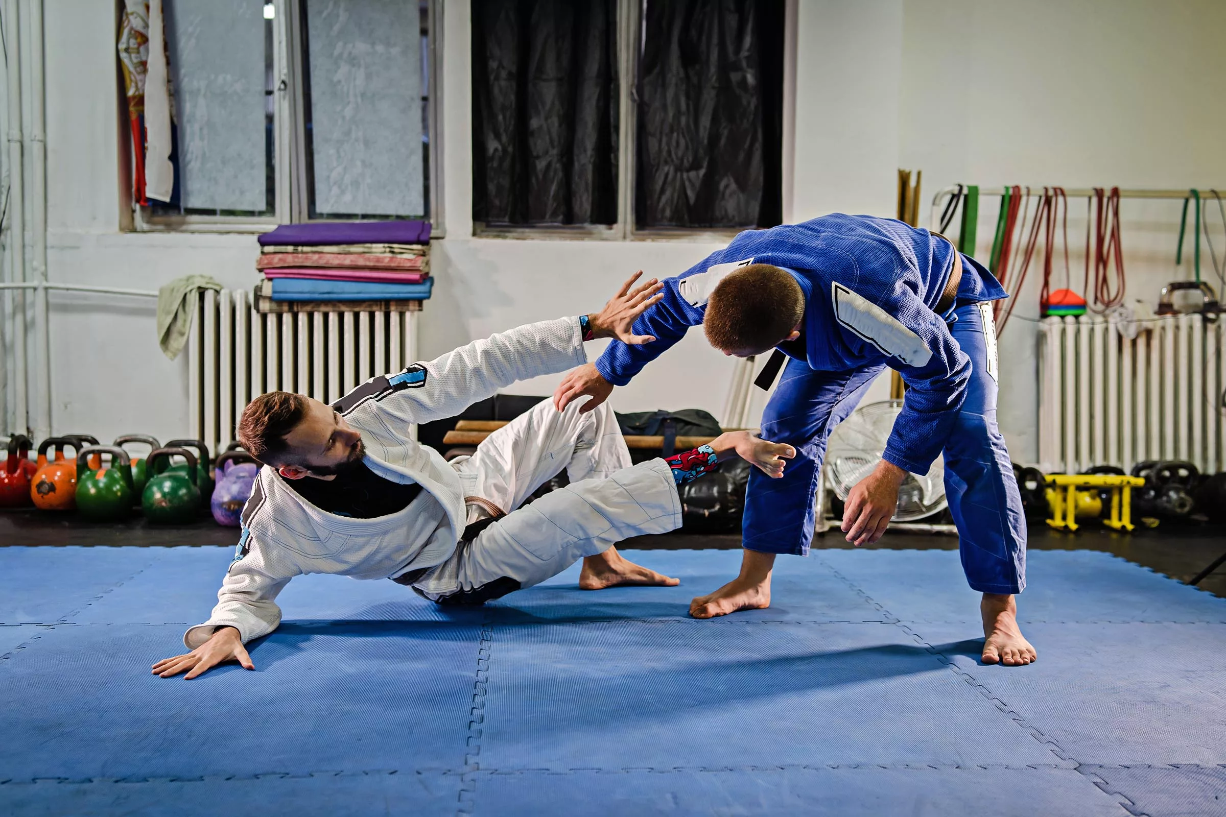 Brazilian Jiu Jitsu BJJ fighters training sparring on the mats at a gym