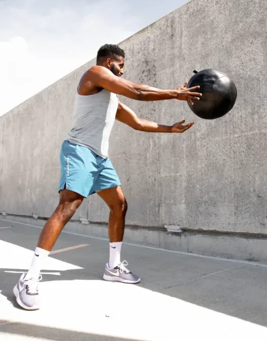 A man throwing a medicine ball against.