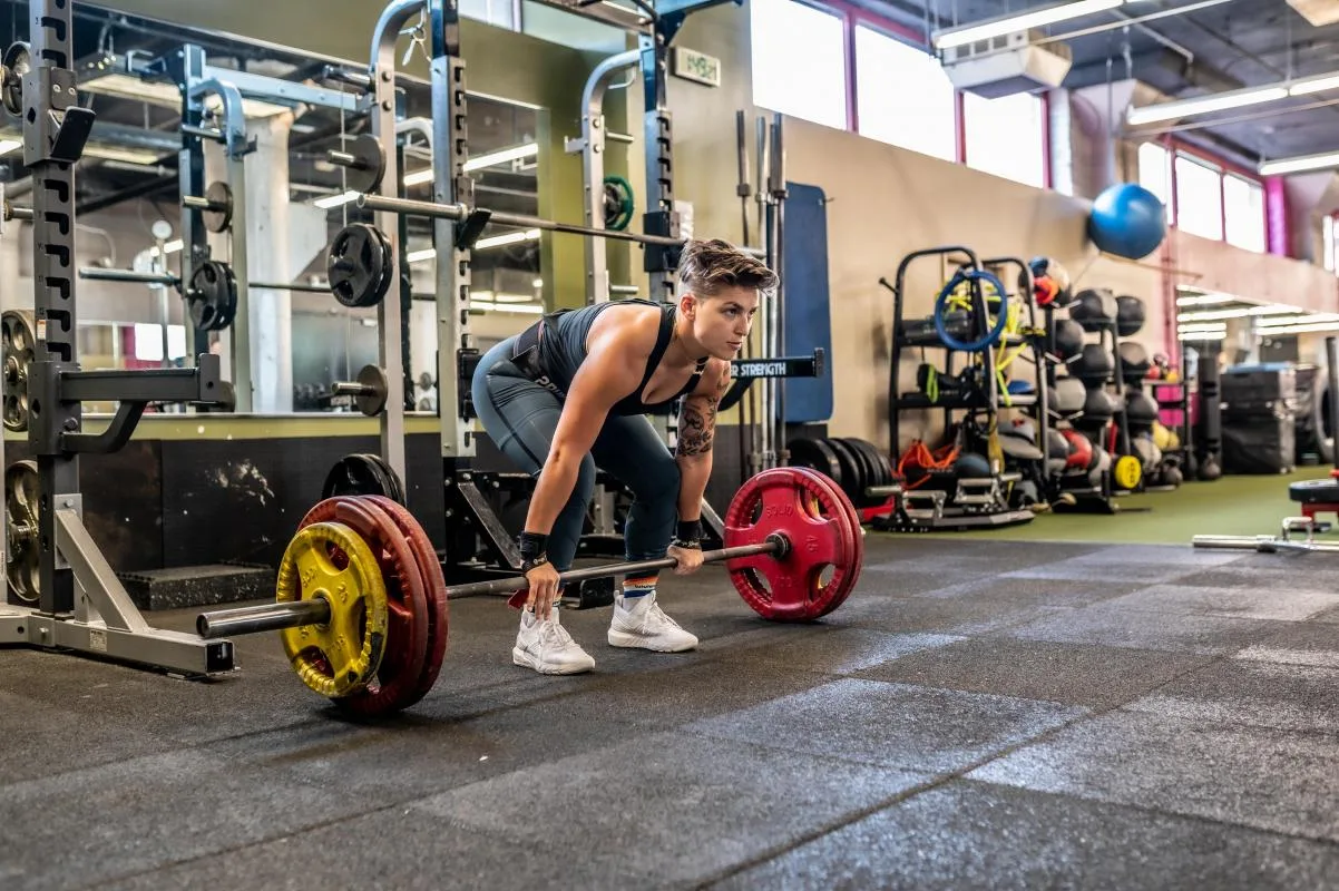 Fit mom doing floor press with her child watching