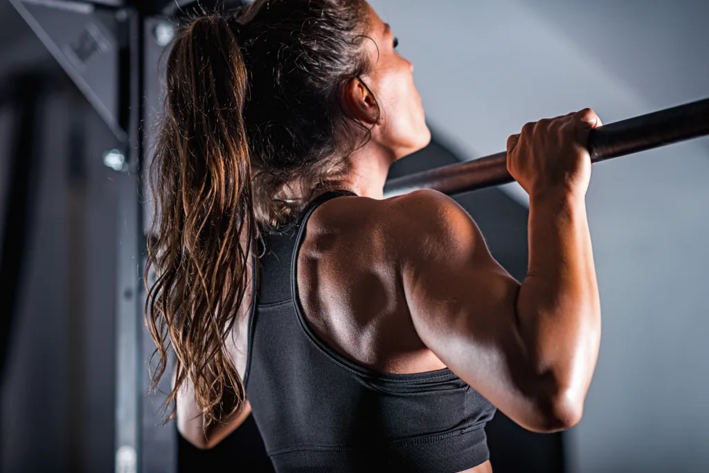 athletic woman doing pull ups and bodyweight training