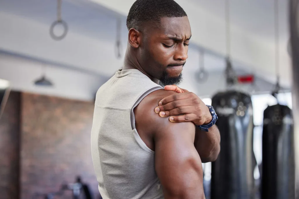 Muscular Nigerian man with a shoulder injury