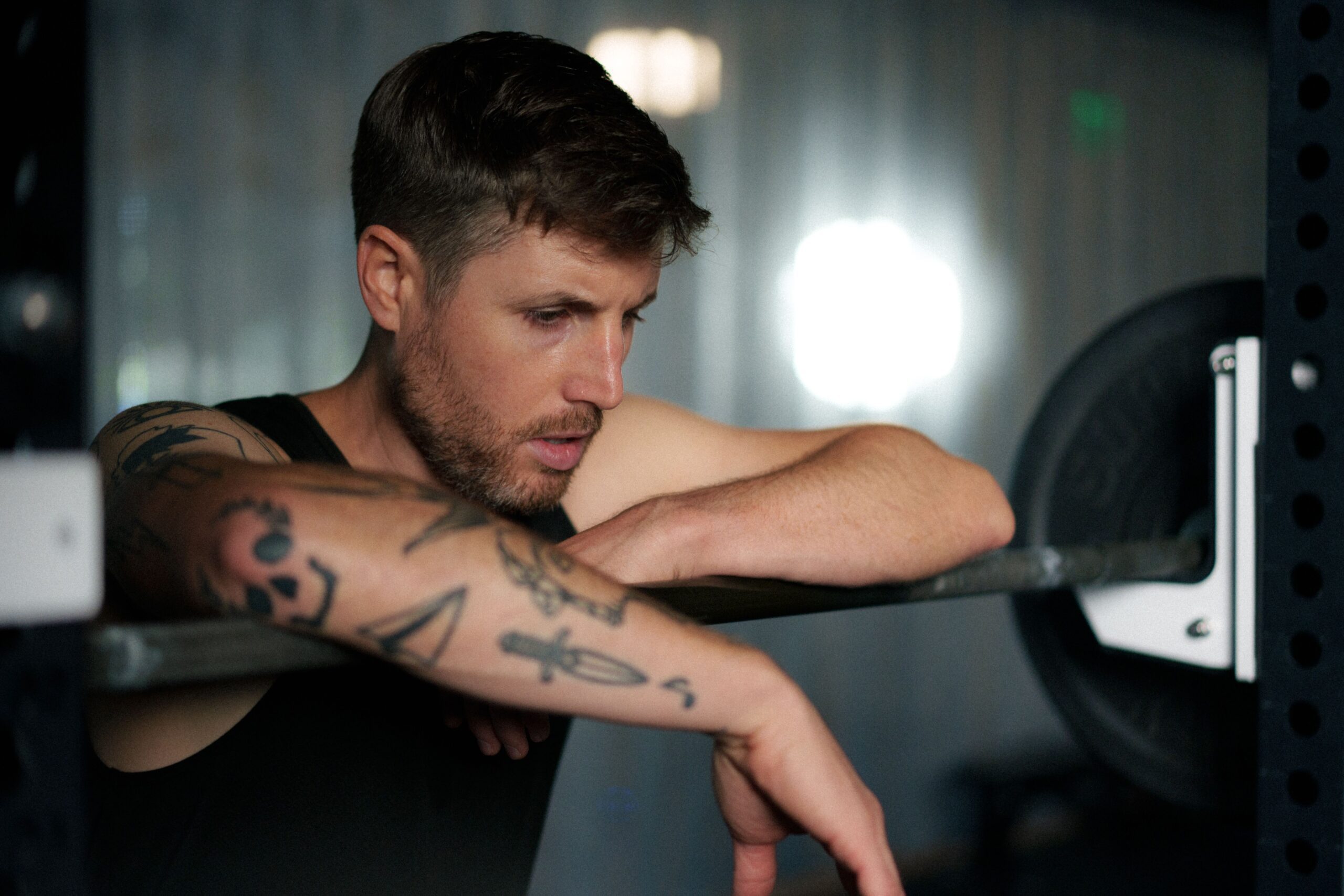 Strength athlete standing by barbell in between reps